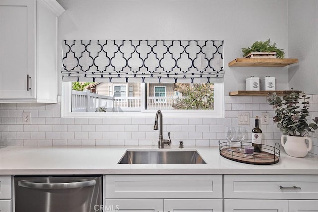 kitchen featuring a sink, white cabinets, light countertops, and stainless steel dishwasher