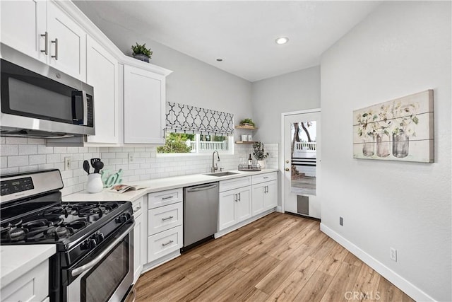 kitchen featuring appliances with stainless steel finishes, decorative backsplash, a sink, and light countertops