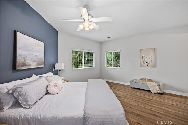 bedroom featuring ceiling fan, baseboards, and wood finished floors