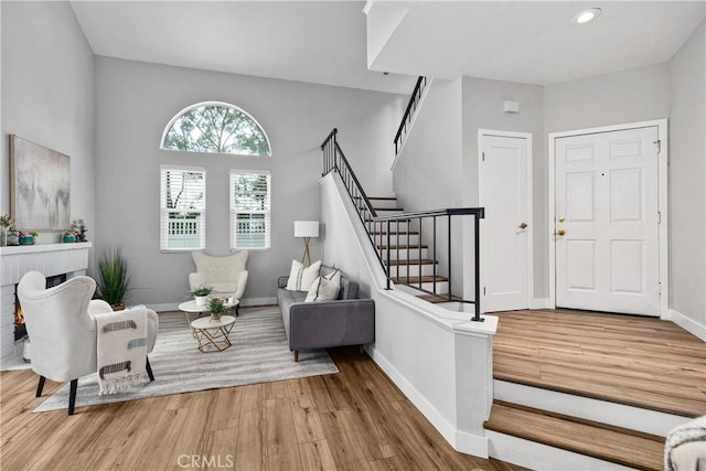 foyer entrance with stairway, recessed lighting, wood finished floors, and baseboards