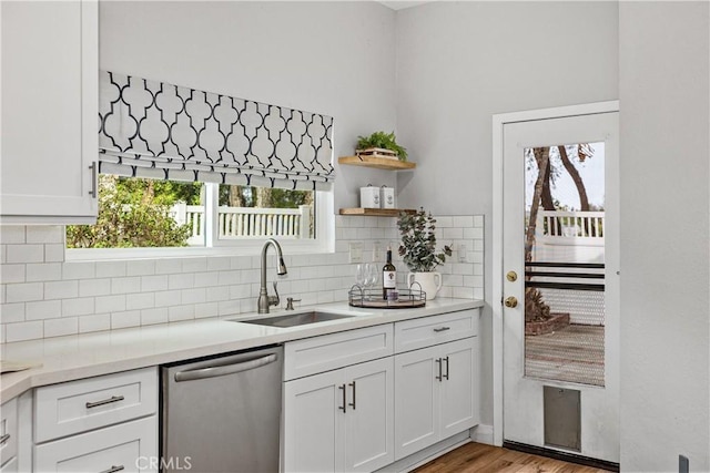 kitchen with dishwasher, plenty of natural light, a sink, and decorative backsplash