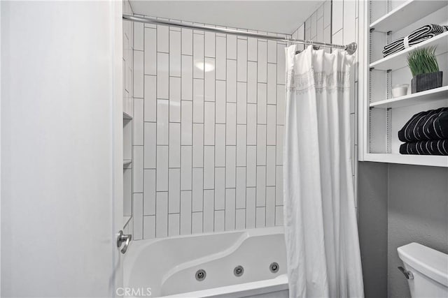 bathroom with toilet and a combined bath / shower with jetted tub