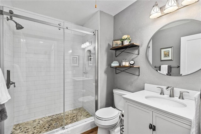 full bath with toilet, a shower stall, and a textured wall