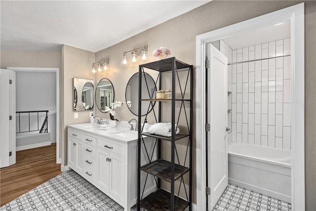 full bath with a sink, baseboards, and double vanity