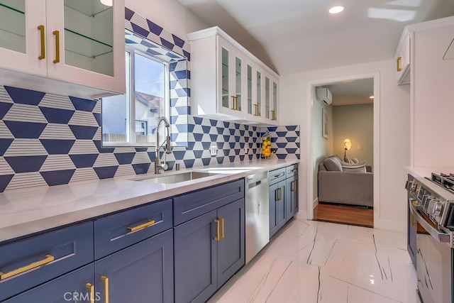 kitchen featuring marble finish floor, stainless steel appliances, light countertops, white cabinetry, and a sink