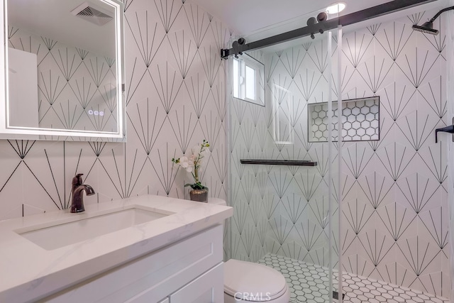 bathroom with toilet, a shower stall, visible vents, and vanity