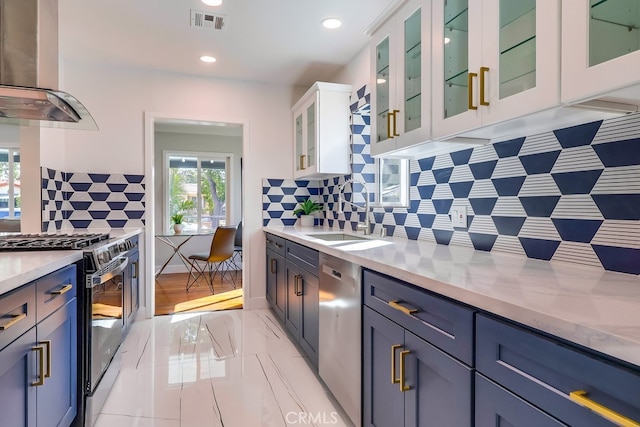 kitchen with visible vents, white cabinets, appliances with stainless steel finishes, island exhaust hood, and a sink