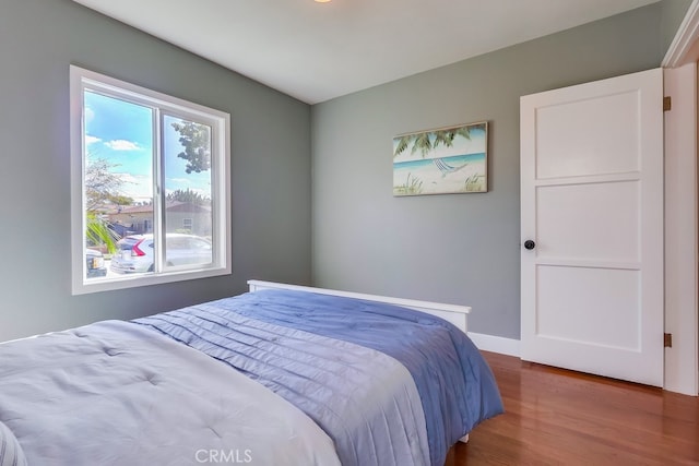 bedroom featuring wood finished floors and baseboards