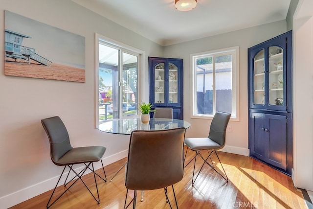 dining area featuring light wood finished floors and baseboards