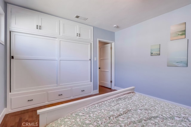 bedroom with dark wood-type flooring, visible vents, and baseboards