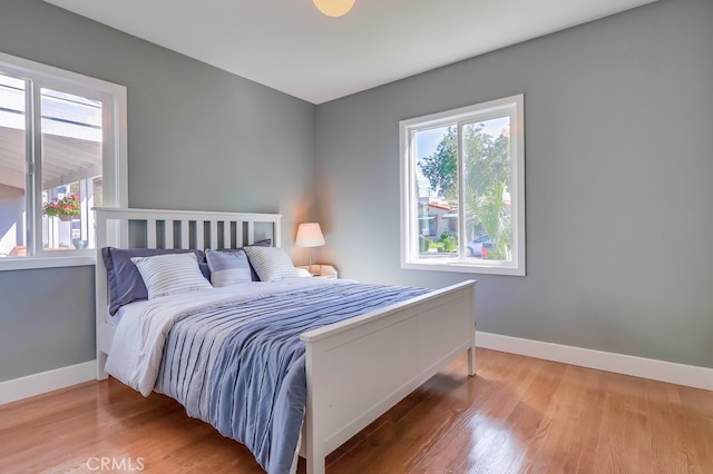 bedroom with baseboards and wood finished floors