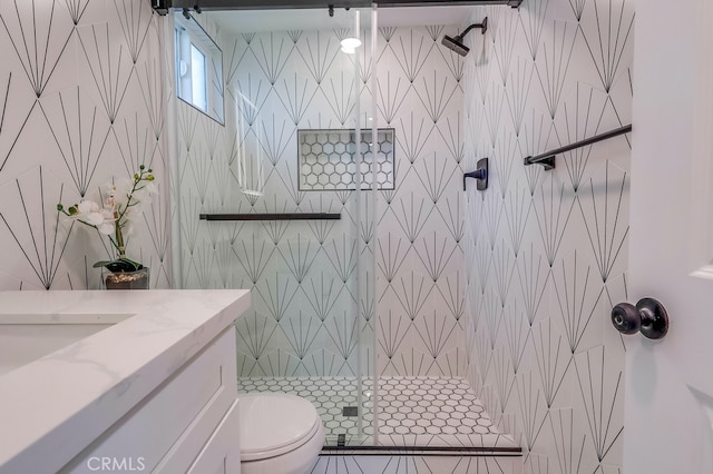 bathroom with toilet, a stall shower, and vanity