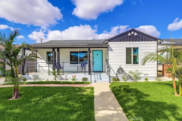 view of front facade featuring a porch, a front lawn, and board and batten siding