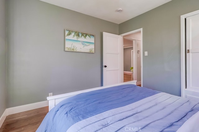 bedroom featuring baseboards and wood finished floors