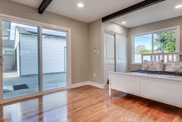 unfurnished bedroom with light wood finished floors, beamed ceiling, recessed lighting, and baseboards