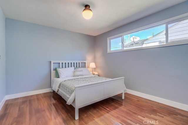 bedroom with wood finished floors and baseboards