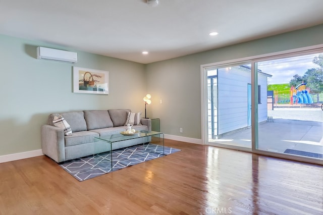 living area with recessed lighting, an AC wall unit, baseboards, and wood finished floors