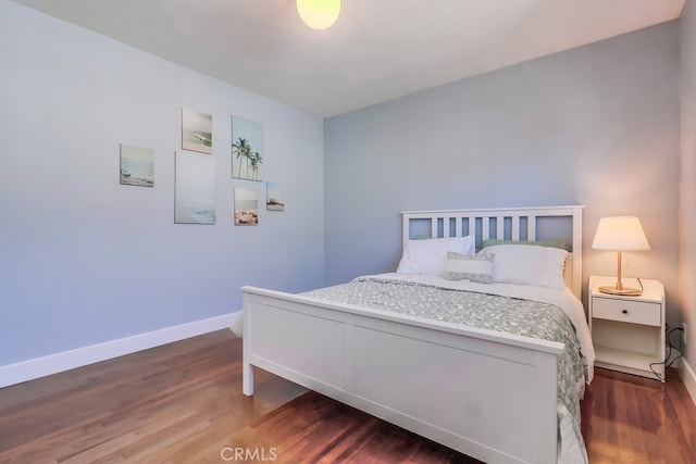 bedroom featuring wood finished floors and baseboards