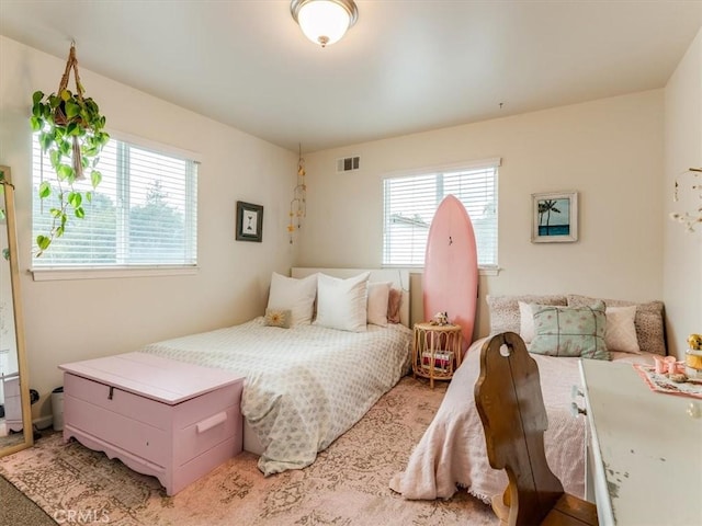 bedroom featuring visible vents and multiple windows