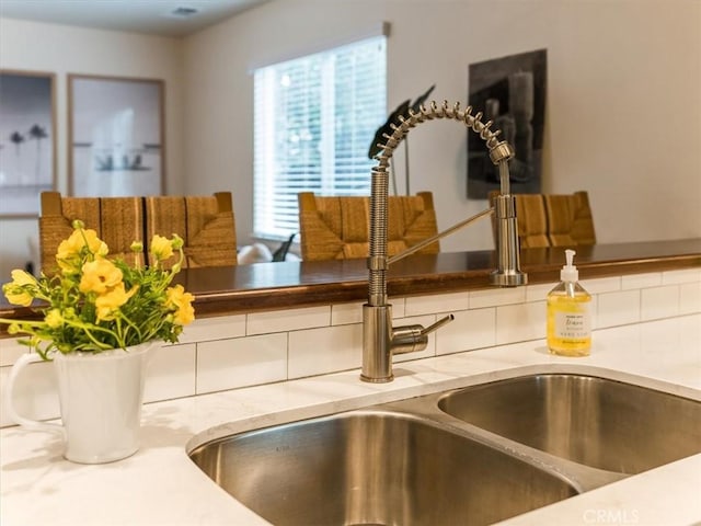 interior details with light stone counters and a sink