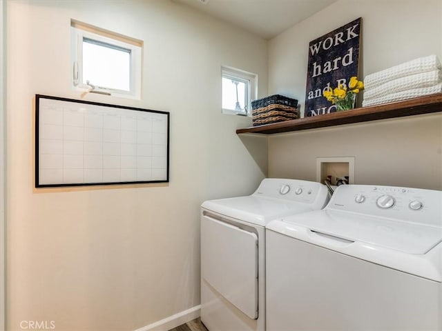 laundry area with laundry area, washing machine and dryer, and baseboards