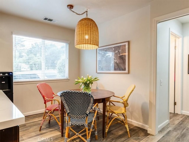 dining room with light wood finished floors, baseboards, and visible vents