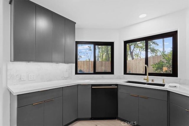 kitchen featuring black dishwasher, modern cabinets, a sink, and gray cabinetry