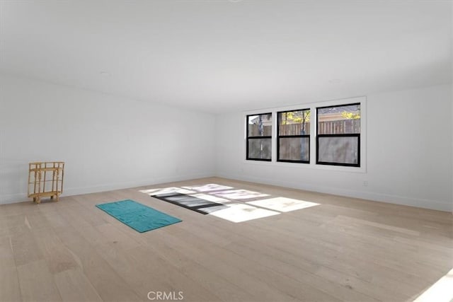 spare room with light wood-type flooring and baseboards