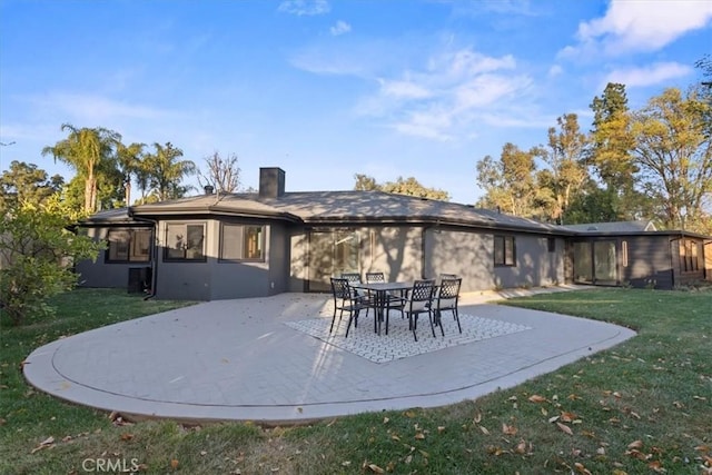 back of property featuring a patio area, a lawn, and stucco siding