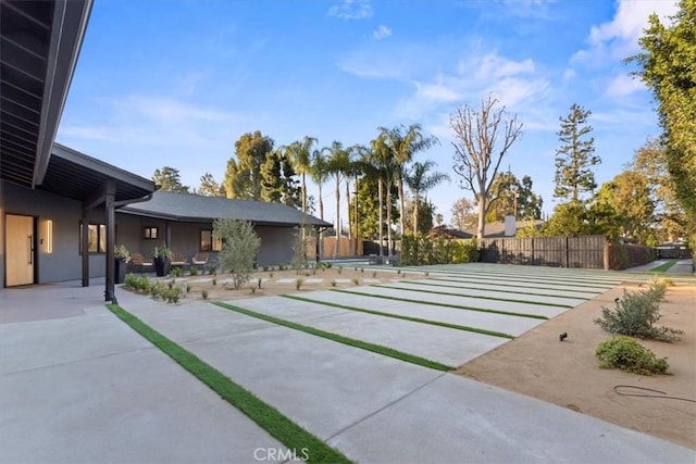 view of yard with a patio area, shuffleboard, and fence