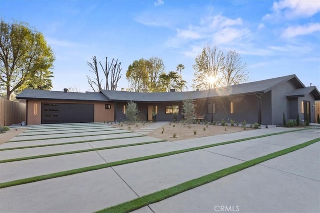 view of front of property featuring an attached garage and fence