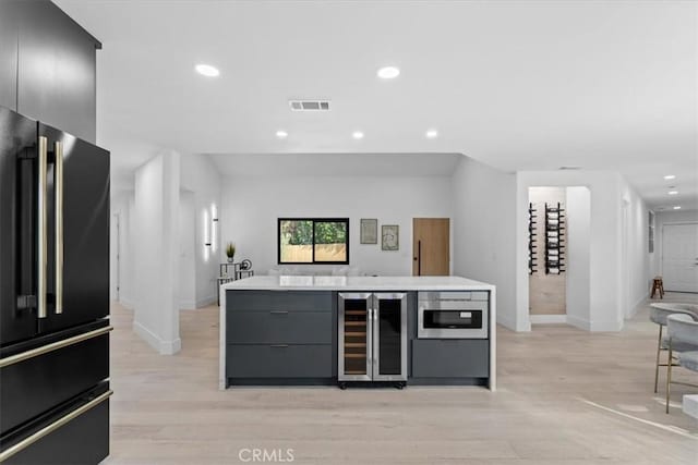 bar featuring wine cooler, visible vents, high quality fridge, and recessed lighting