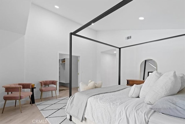 bedroom with light wood-style floors, visible vents, high vaulted ceiling, and recessed lighting