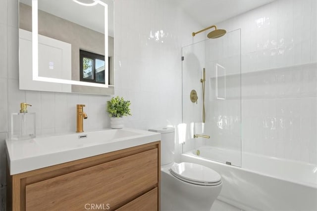 full bathroom with toilet, shower / washtub combination, tile walls, and vanity