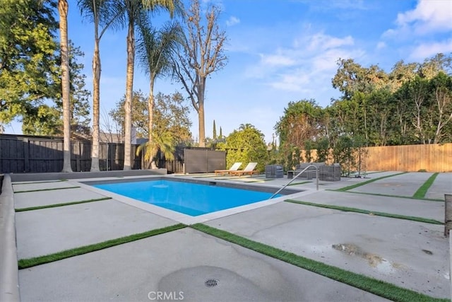 view of swimming pool featuring a patio area, fence, and a fenced in pool