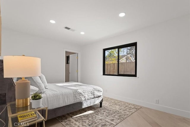 bedroom with baseboards, visible vents, wood finished floors, and recessed lighting