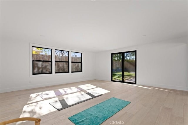 spare room featuring light wood finished floors and baseboards