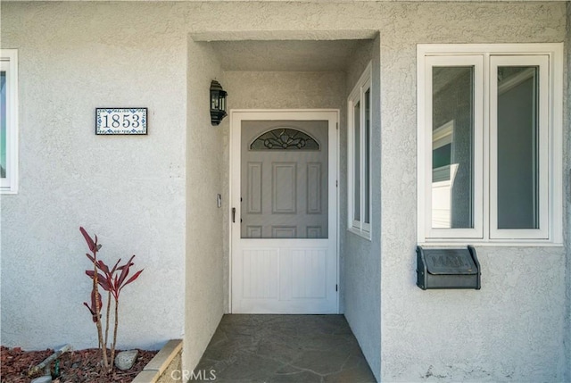 property entrance featuring stucco siding