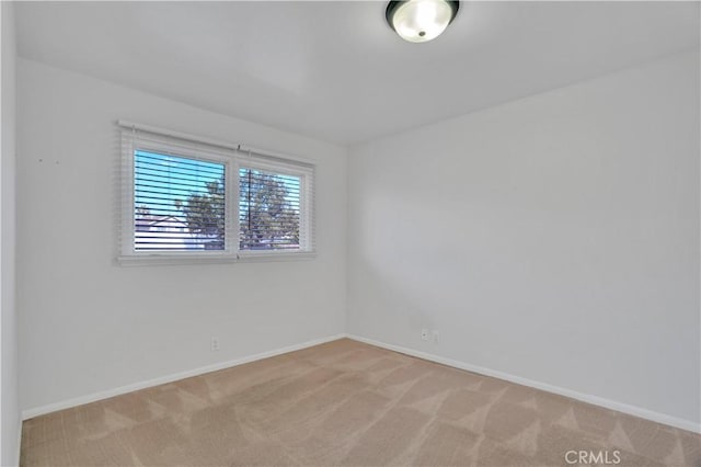 carpeted empty room with baseboards