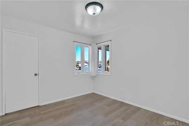 empty room with baseboards and wood finished floors