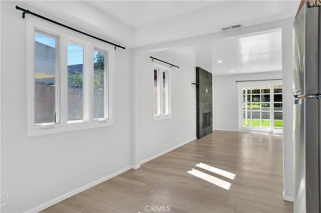 spare room with a fireplace, recessed lighting, visible vents, light wood-style flooring, and baseboards