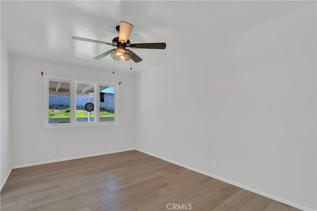 unfurnished room with ceiling fan, wood finished floors, and baseboards