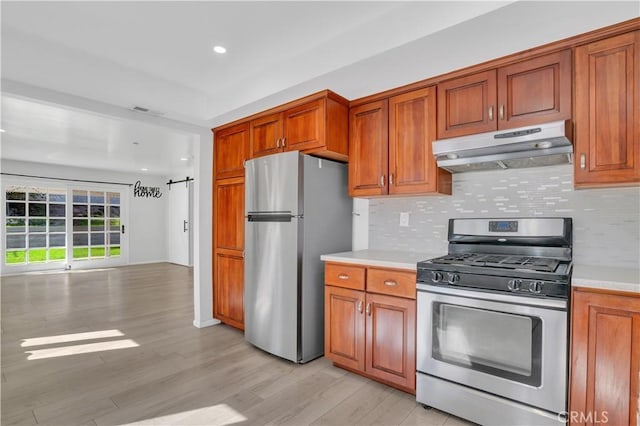 kitchen with light countertops, appliances with stainless steel finishes, backsplash, and under cabinet range hood