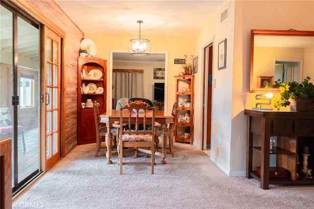 carpeted dining area featuring visible vents and a notable chandelier