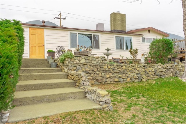 exterior space with entry steps and a chimney