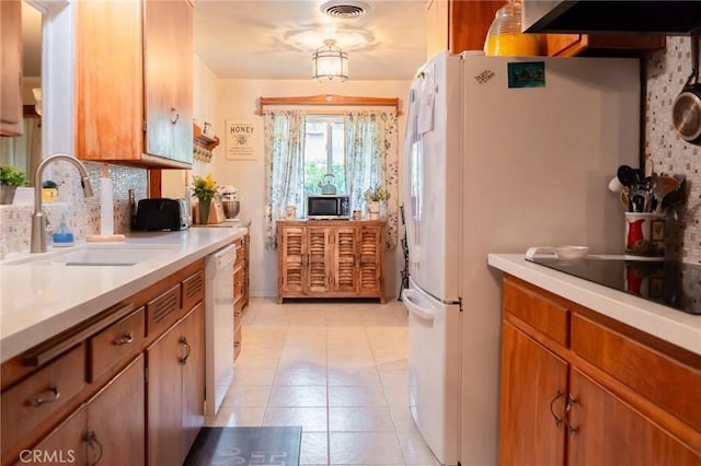 kitchen with light countertops, white appliances, visible vents, and a sink