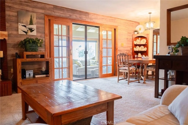 interior space featuring a chandelier, french doors, and wooden walls