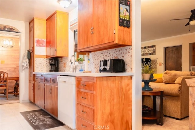 kitchen featuring white dishwasher, a ceiling fan, open floor plan, light countertops, and backsplash