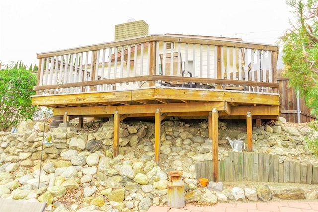 back of property with a deck and a chimney