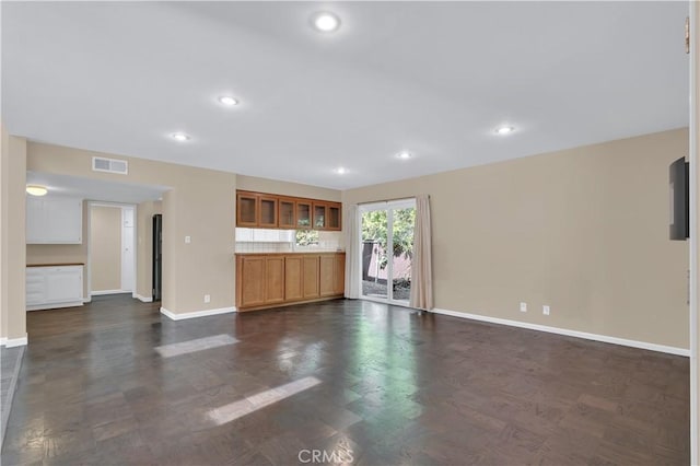 unfurnished living room featuring visible vents, baseboards, and recessed lighting